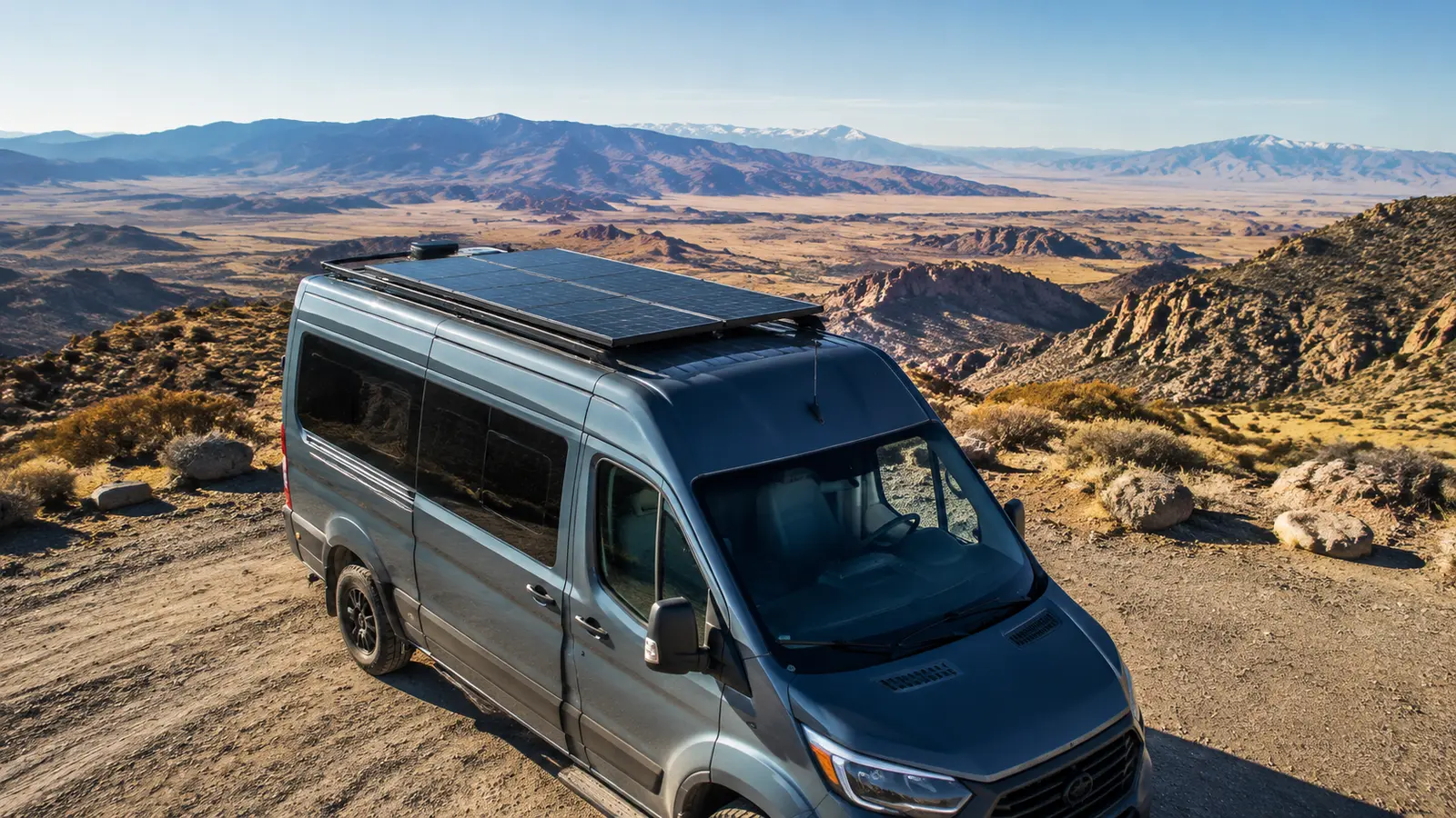 Camper van with rigid solar panels mounted on the roof in a sunny high-desert landscape